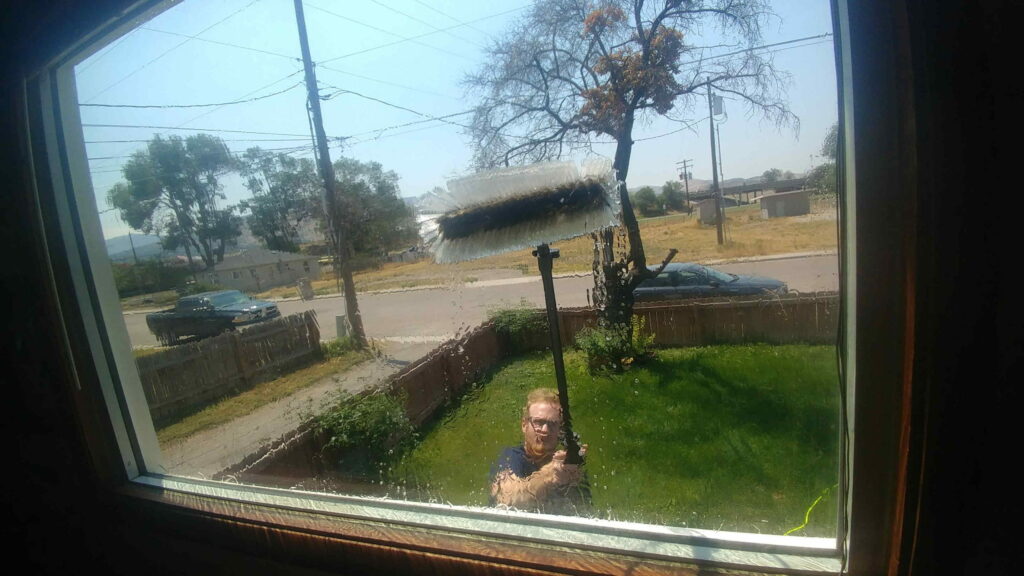 Easy Clean window washer cleaning a front window with a water-fed pole