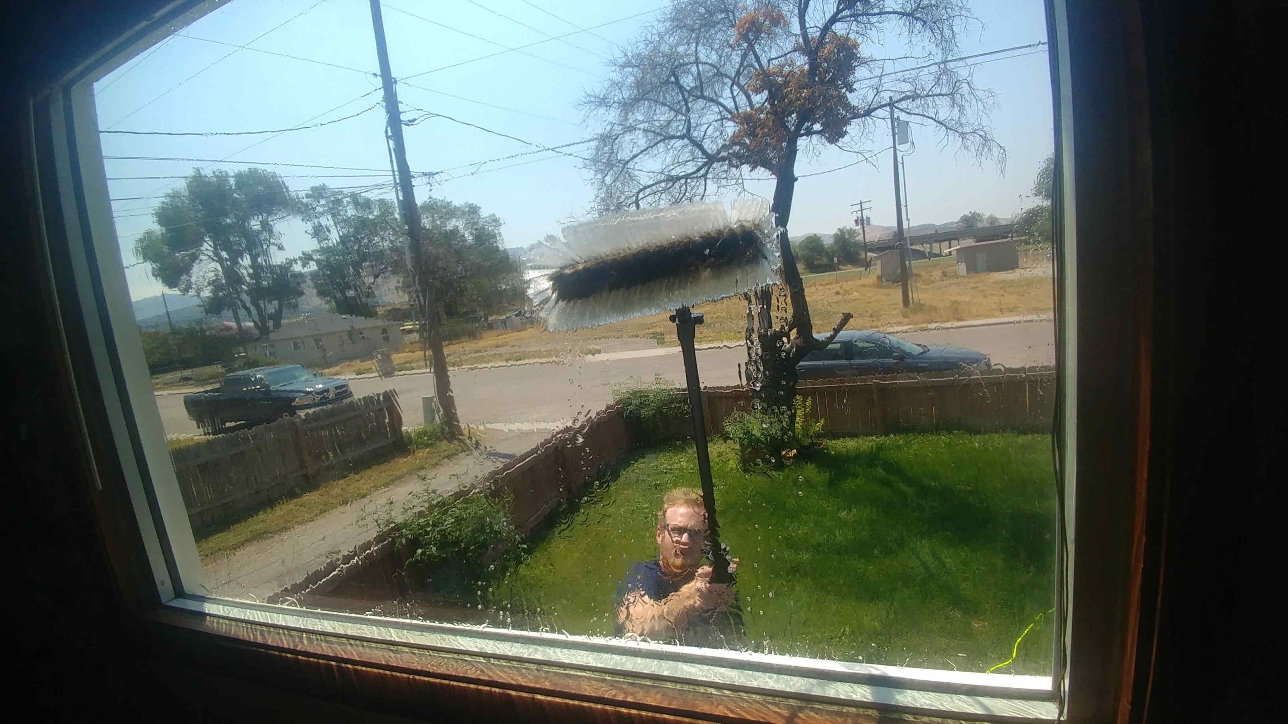 Easy Clean window washer cleaning a home's front window with a water-fed pole brush