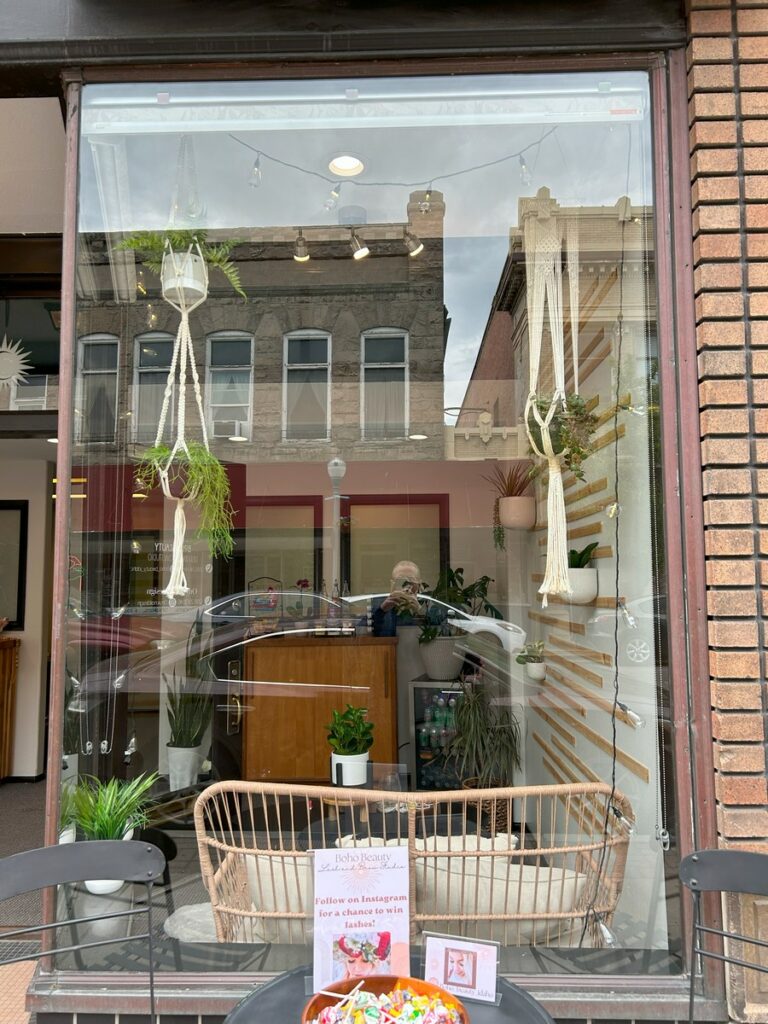 Downtown Pocatello shop window cleaned, with historic buildings reflected in the glass